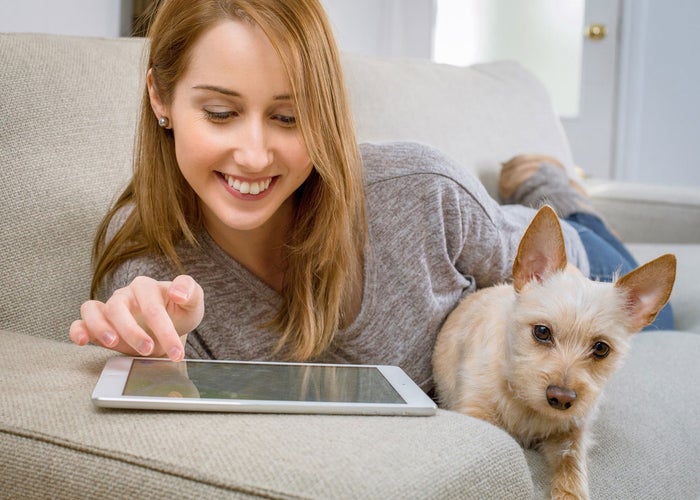 woman with ipad next to dog